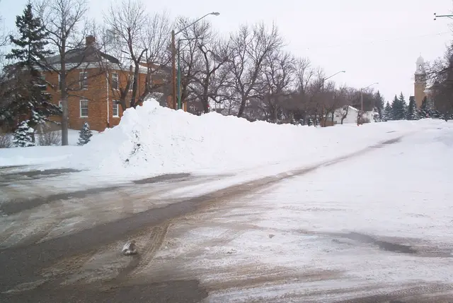 Snowy street with brick building and church tower