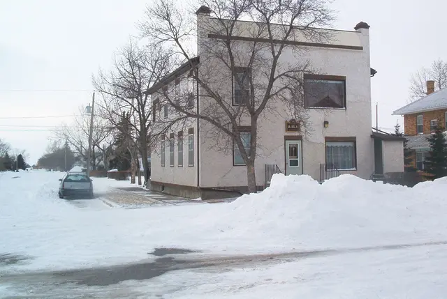 Two-storey stucco building on a snowy street